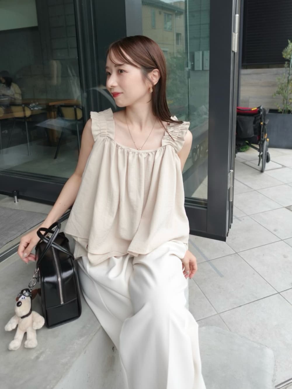 ベージュ系のキャミソール、ホワイト系のその他パンツ、ブラック系のサンダルを着用したレディースの夏コーディネートの2枚目の写真