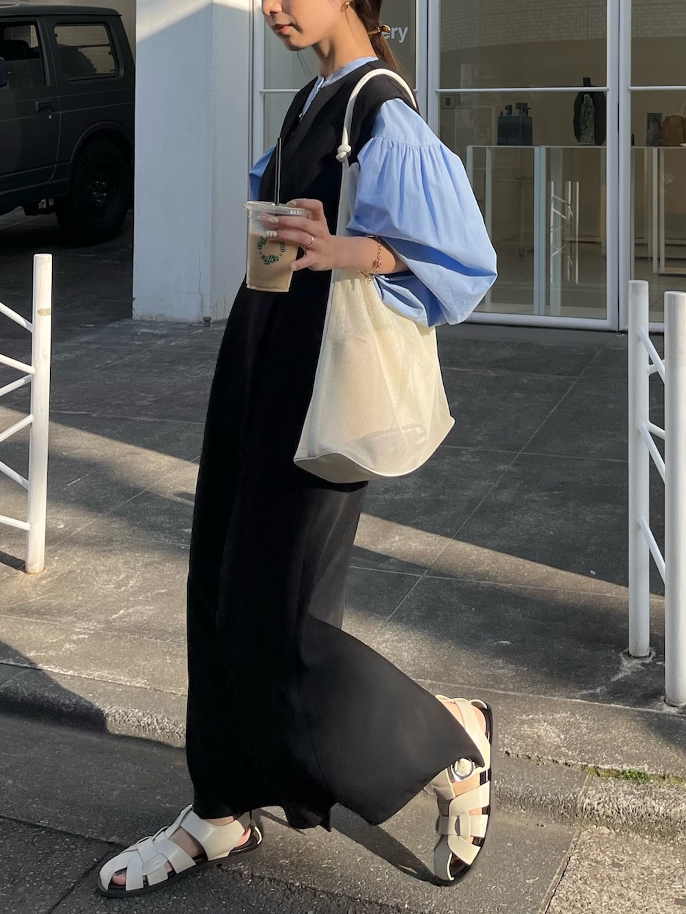 ブラック系のワンピース/ドレス、ブルー系のシャツ/ブラウス、ホワイト系のサンダルを着用したレディースの春コーディネートの5枚目の写真