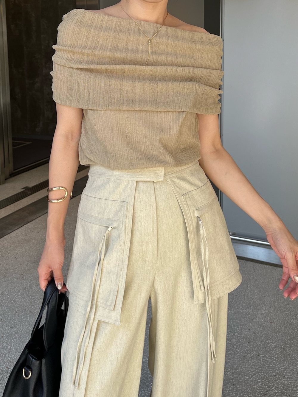 ベージュ系のその他パンツ、ベージュ系のニット/セーター、ブラック系のショルダーバッグを着用したレディースの夏コーディネートの4枚目の写真