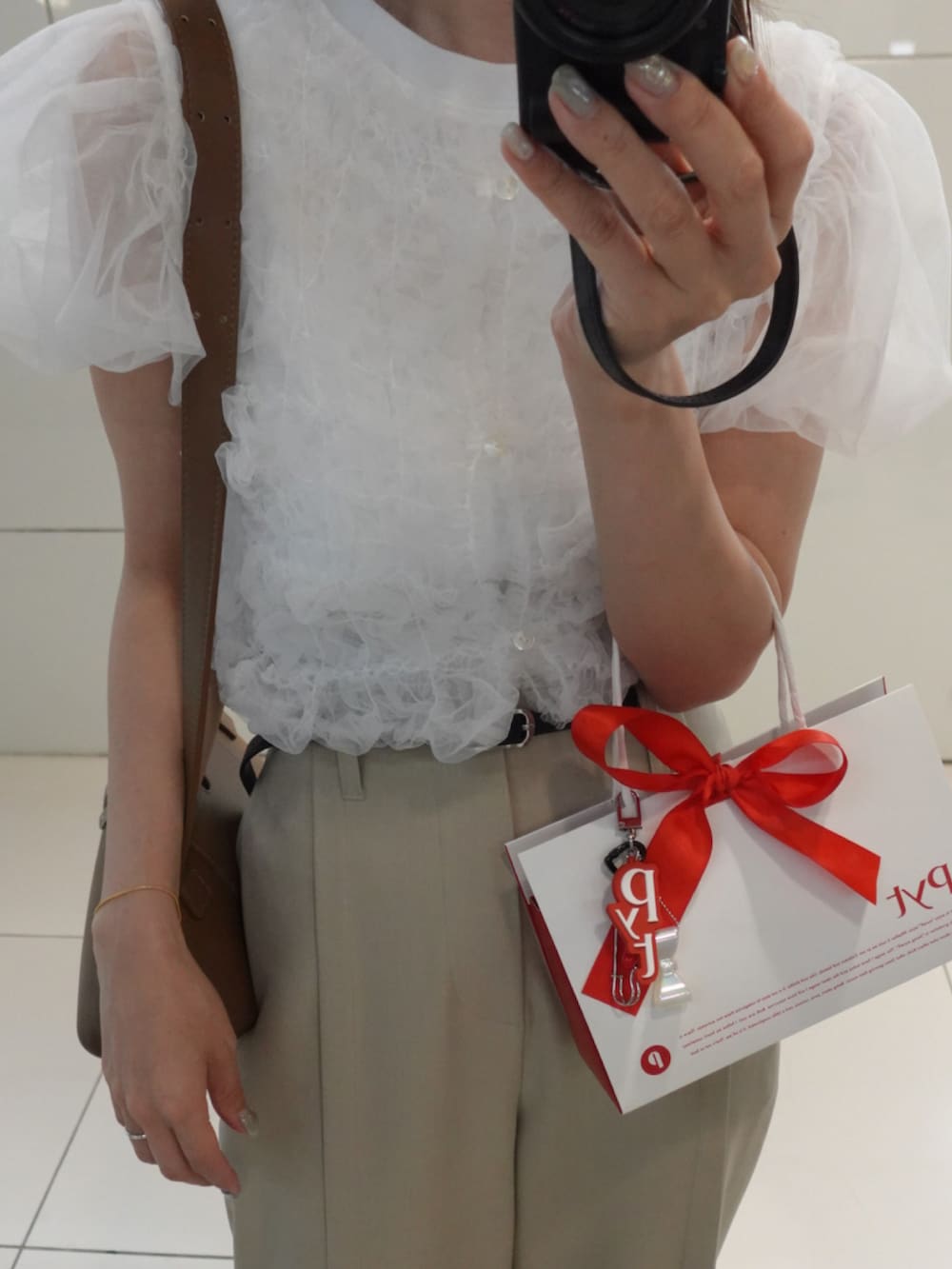 イエロー系のショルダーバッグ、ベージュ系のその他パンツ、ホワイト系のTシャツ/カットソーを着用したレディースの夏コーディネートの4枚目の写真