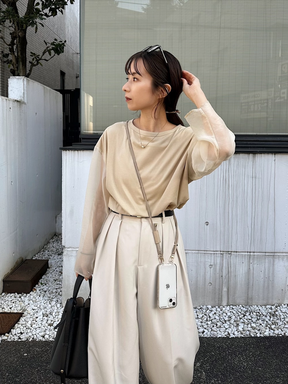 ホワイト系のその他パンツ、ベージュ系のTシャツ/カットソー、ブラック系のバッグを着用したレディースの冬コーディネートの4枚目の写真