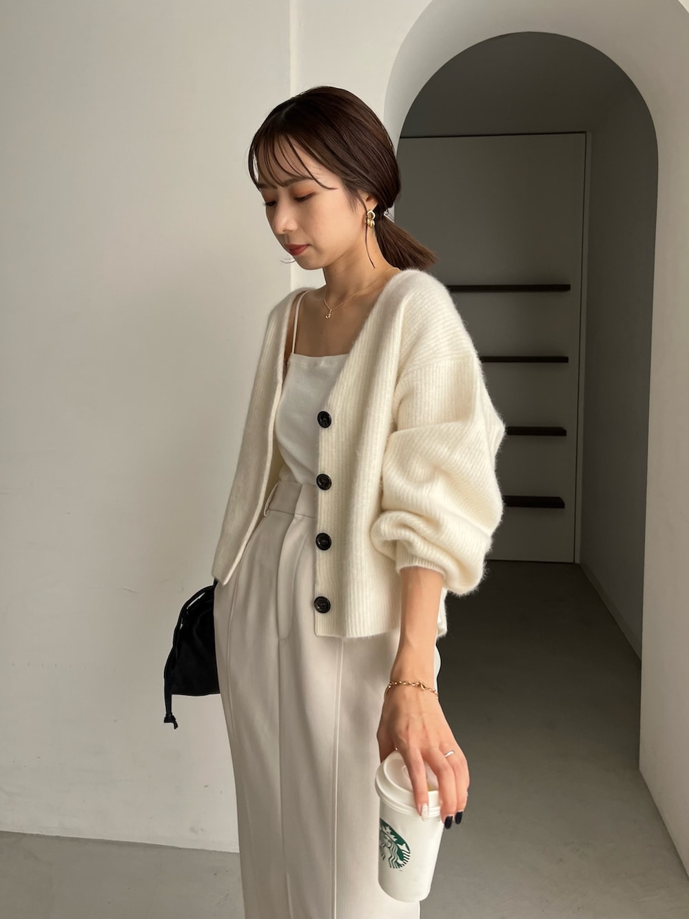 ホワイト系のカーディガン/ボレロ、ブラック系のパンプス、ホワイト系のスカートを着用したレディースの秋コーディネートの5枚目の写真