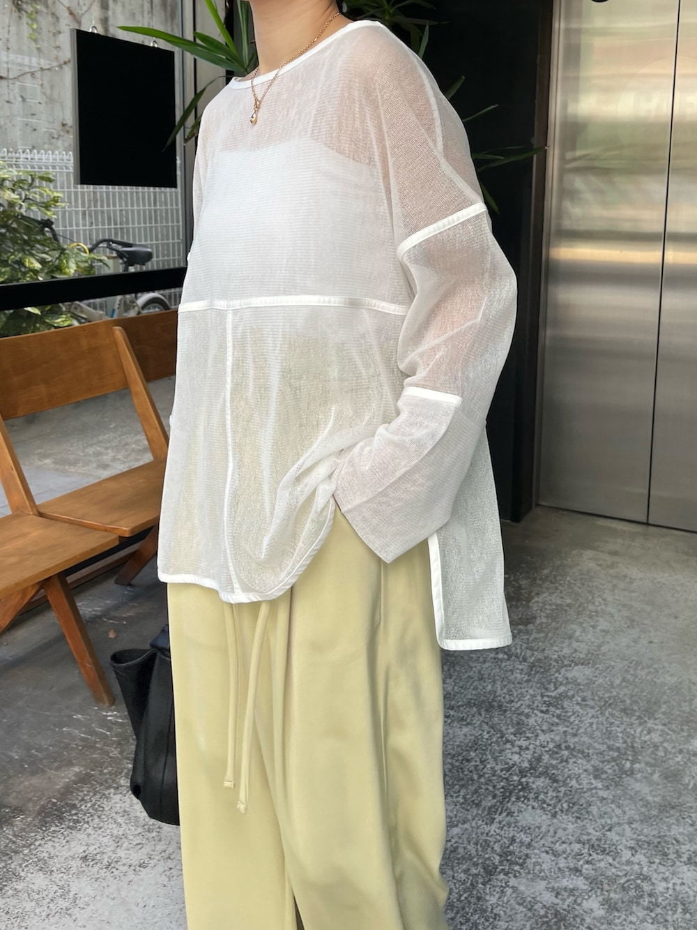 ホワイト系のTシャツ/カットソー、グリーン系のその他パンツ、ブラック系のハンドバッグを着用したレディースの冬コーディネートの5枚目の写真