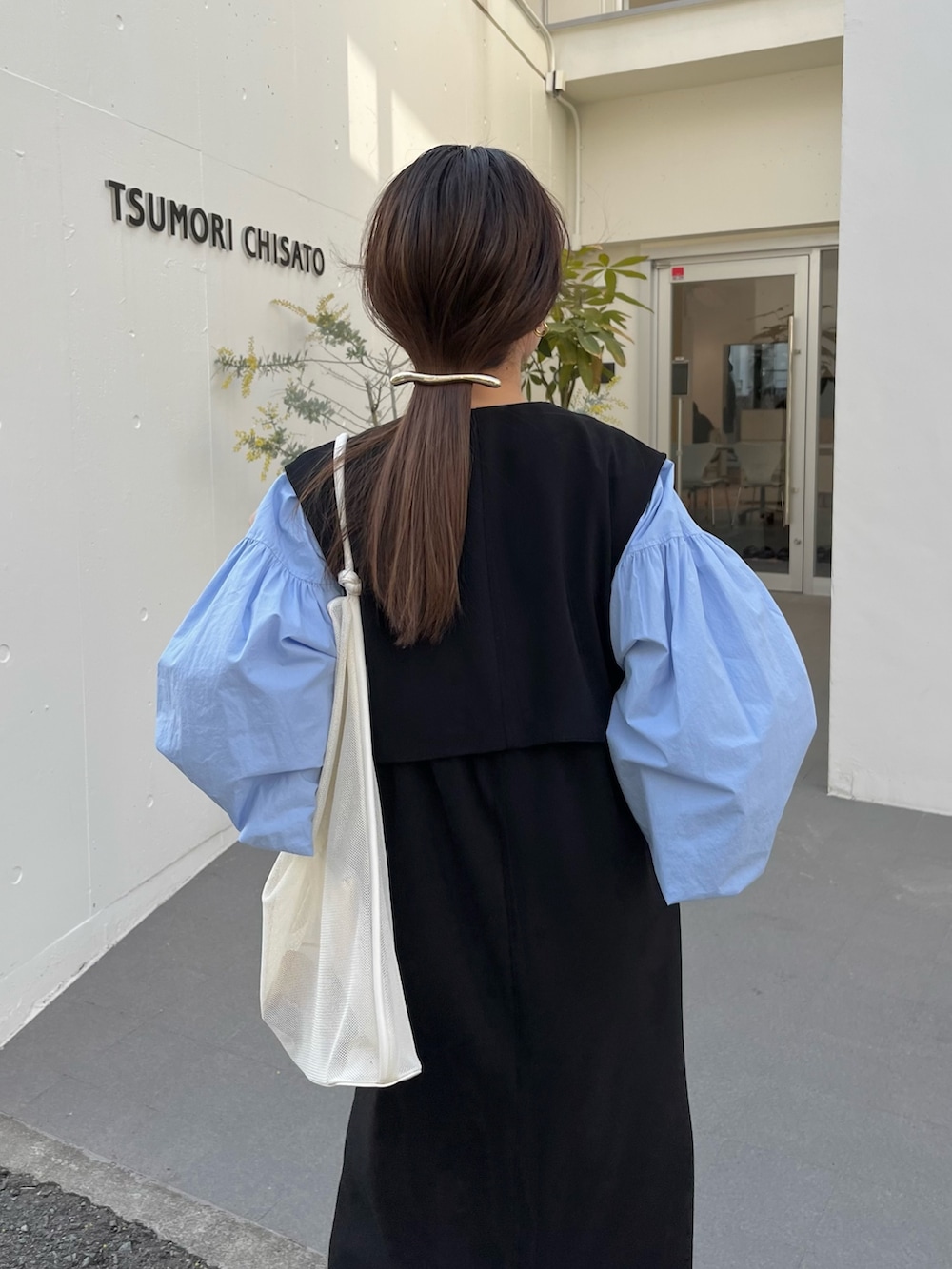 ブラック系のワンピース/ドレス、ブルー系のシャツ/ブラウス、ホワイト系のサンダルを着用したレディースの春コーディネートの7枚目の写真