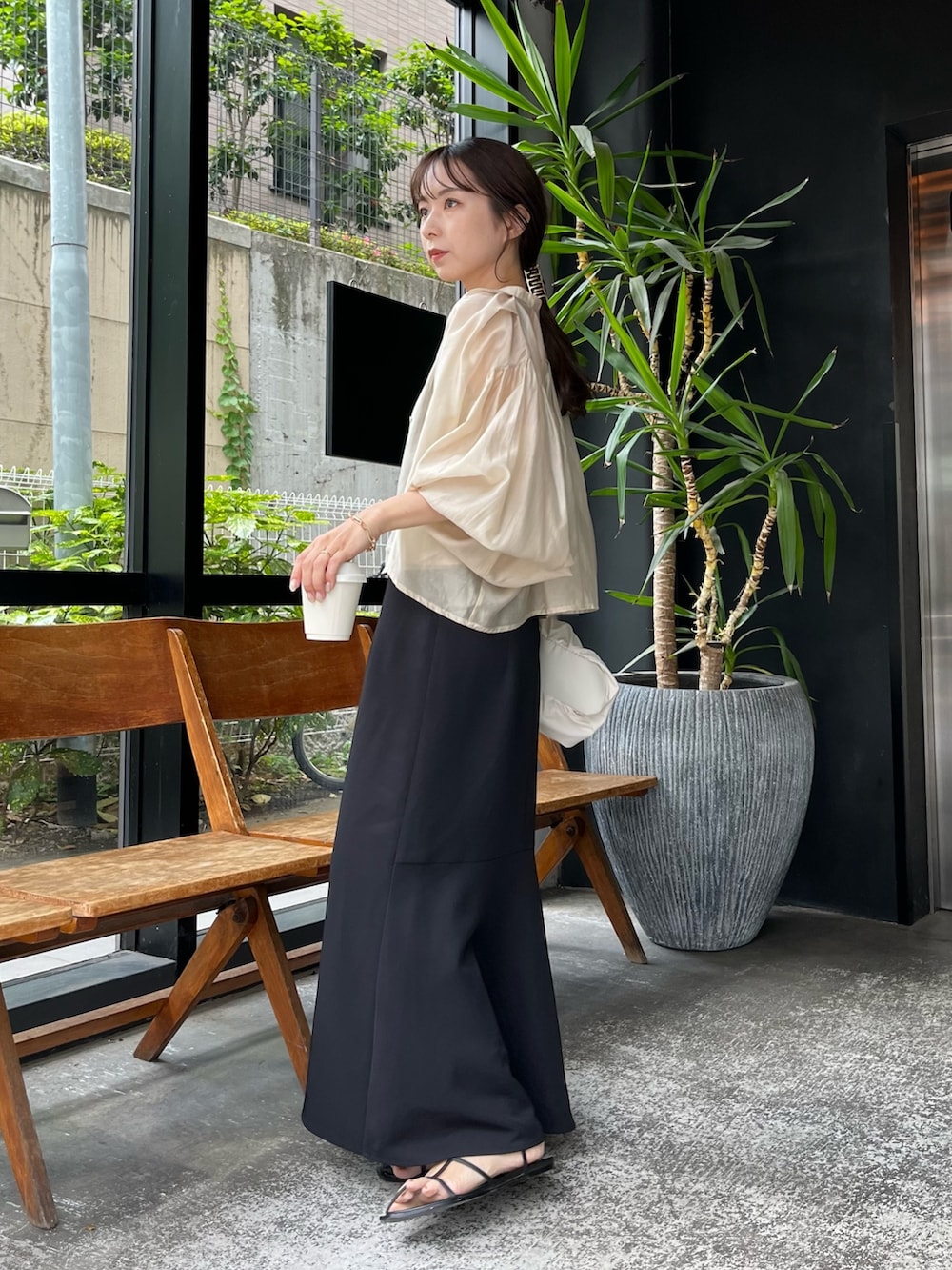 ベージュ系のシャツ/ブラウス、ブラック系のワンピース、ホワイト系のバッグを着用したレディースの夏コーディネートの3枚目の写真