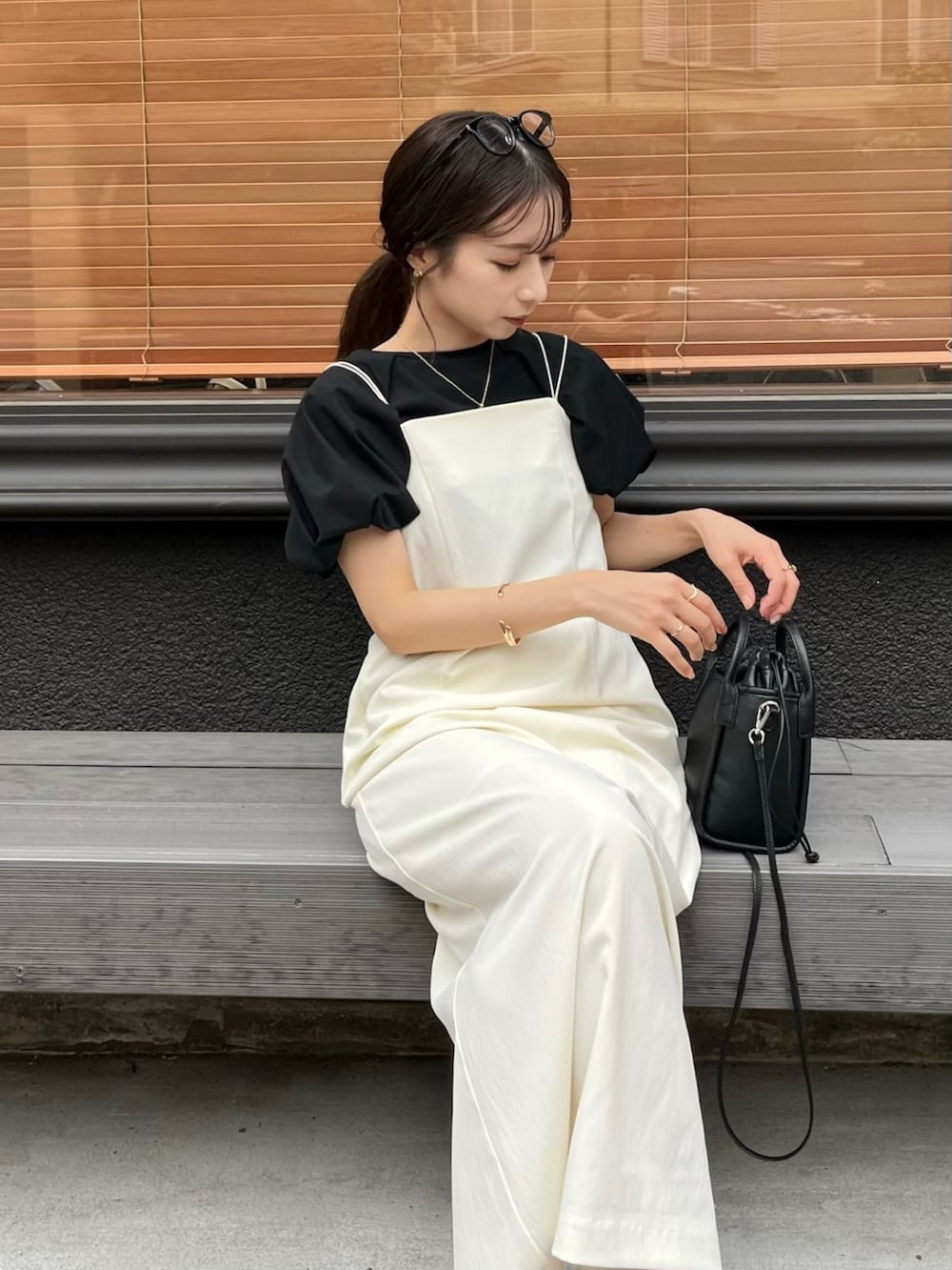 ホワイト系のワンピース、ブラック系のTシャツ/カットソー、ホワイト系のショルダーバッグを着用したレディースの夏コーディネートの3枚目の写真