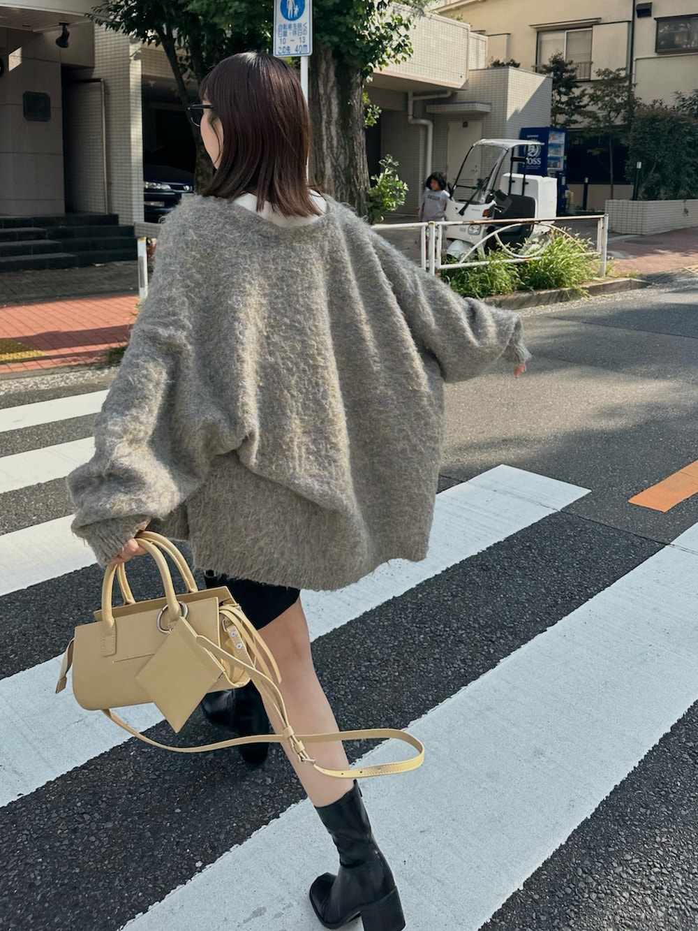 グレー系のカーディガン/ボレロ、ホワイト系のタンクトップ、ブラック系のその他パンツを着用したレディースの秋コーディネートの2枚目の写真
