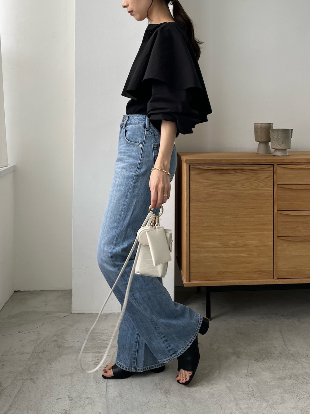 ブラック系のシャツ/ブラウス、ブルー系のデニムパンツ、ホワイト系のトートバッグを着用したレディースの夏コーディネートの3枚目の写真