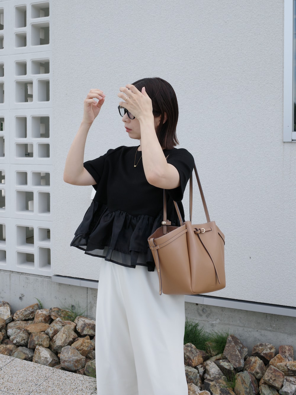 ブラック系のTシャツ/カットソー、ホワイト系のその他パンツ、イエロー系のショルダーバッグを着用したレディースの夏コーディネートの2枚目の写真
