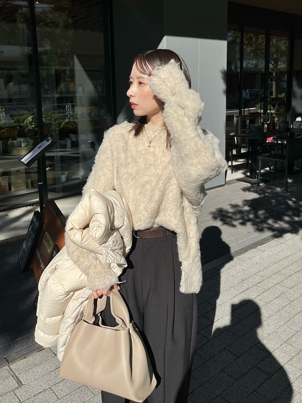 ベージュ系のニット/セーター、ブラック系のスラックス、ブラック系のブーツを着用したレディースの冬コーディネートの2枚目の写真