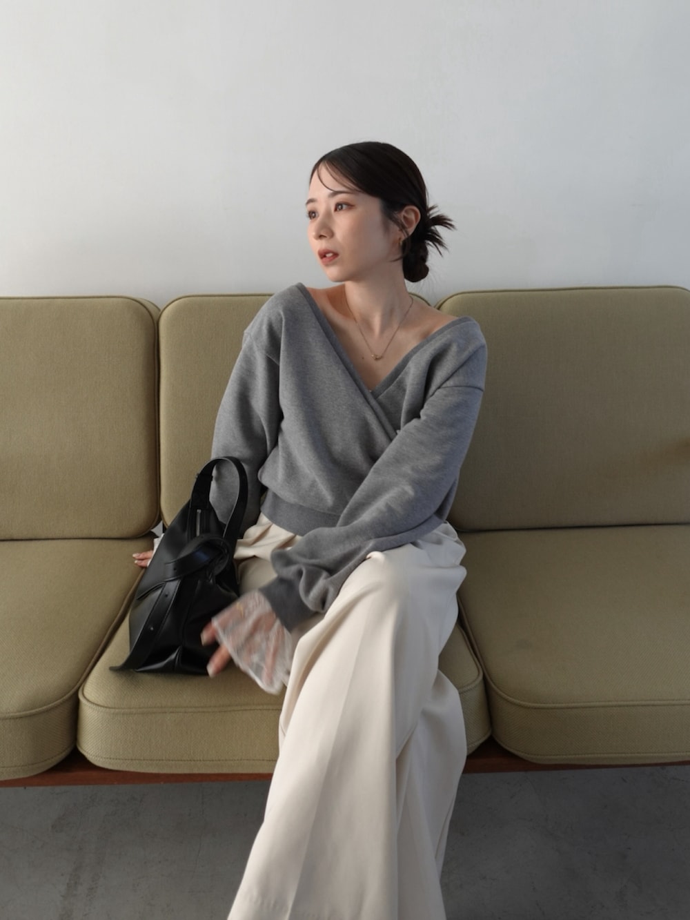 グレー系のTシャツ/カットソー、ホワイト系のその他パンツ、ブラック系のショルダーバッグを着用したレディースの冬コーディネートの2枚目の写真