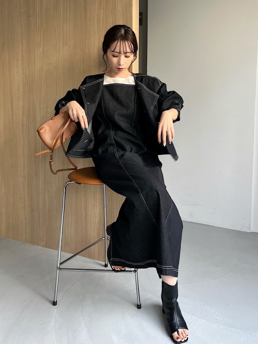 ブラック系のワンピース、ブラック系のデニムジャケット、ホワイト系のニット/セーターを着用したレディースの冬コーディネートの2枚目の写真