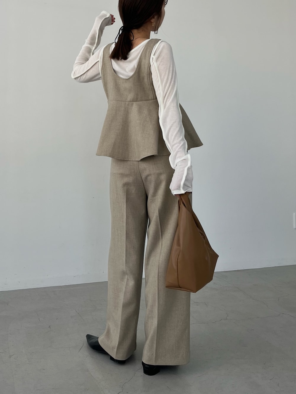 ベージュ系のその他パンツ、イエロー系のショルダーバッグ、ブラック系のパンプスを着用したレディースの冬コーディネートの3枚目の写真