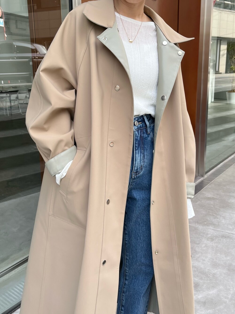 ブルー系のデニムパンツ、グリーン系のその他アウター、ホワイト系のニット/セーターを着用したレディースの冬コーディネートの6枚目の写真