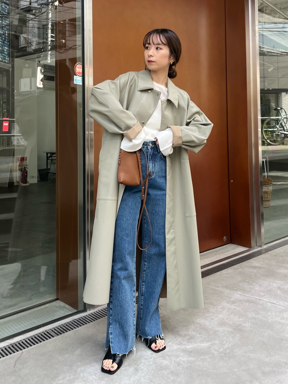 ブルー系のデニムパンツ、グリーン系のその他アウター、ホワイト系のニット/セーターを着用したレディースの冬コーディネートの2枚目の写真