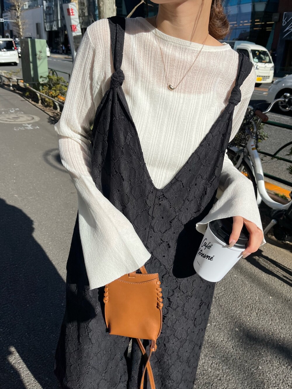 ホワイト系のニット/セーター、ブラック系のサロペット/オーバーオール、ブラウン系のトートバッグを着用したレディースの冬コーディネートの3枚目の写真