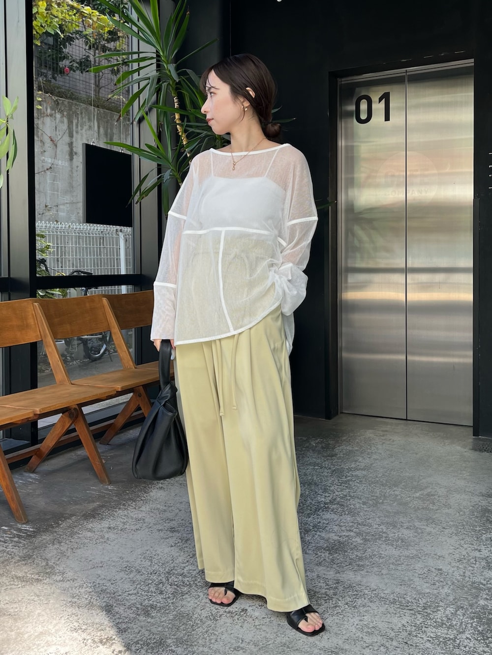 ホワイト系のTシャツ/カットソー、グリーン系のその他パンツ、ブラック系のハンドバッグを着用したレディースの冬コーディネートの2枚目の写真