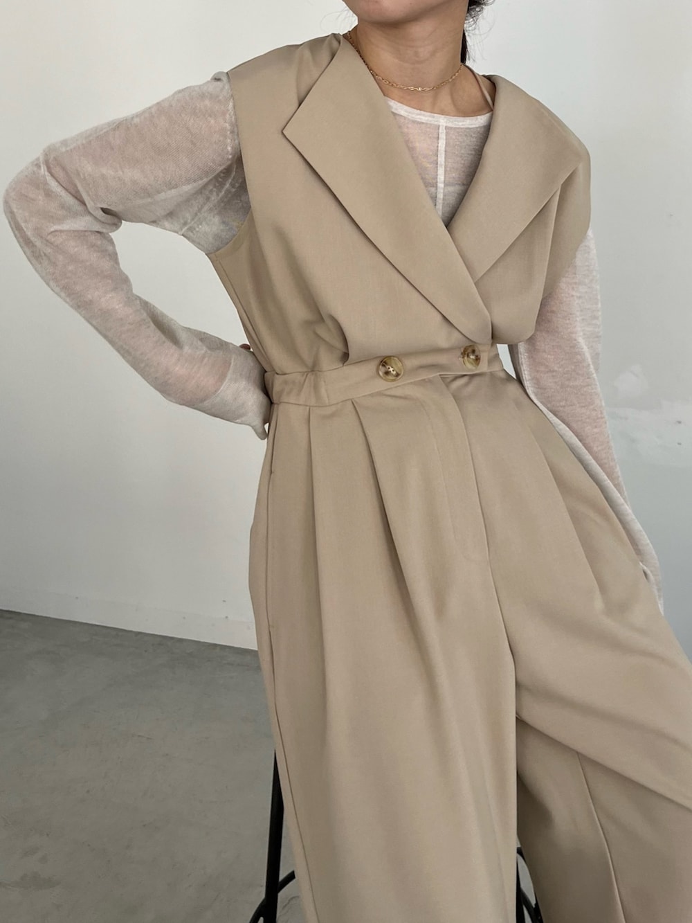 ブラック系のパンプス、ホワイト系のニット/セーター、ベージュ系のつなぎ/オールインワンを着用したレディースの冬コーディネートの7枚目の写真