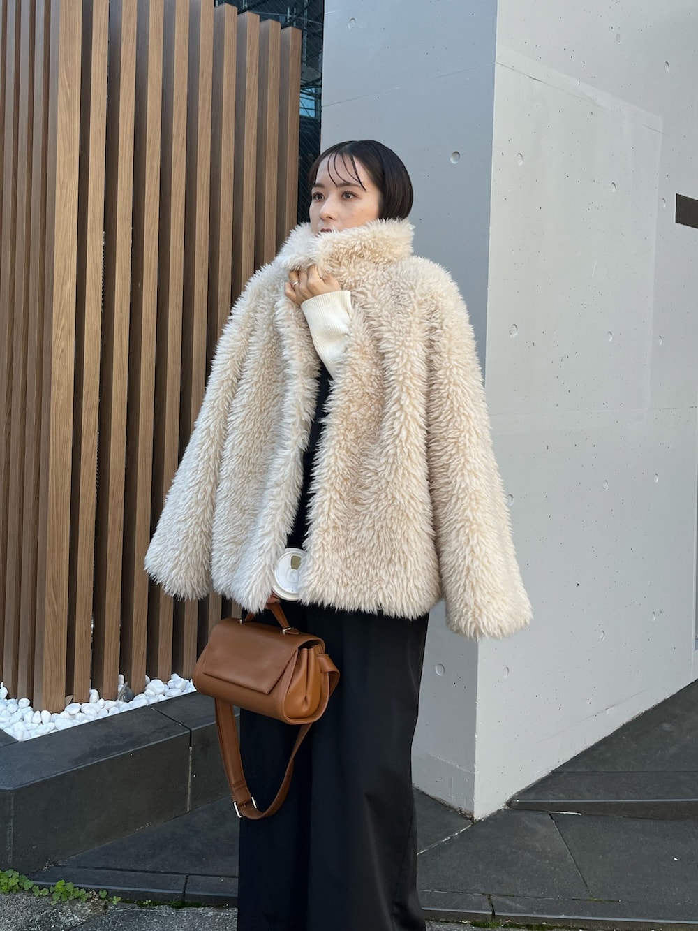 ブラック系のスカート、ホワイト系のニット/セーター、ホワイト系のダウンジャケット/コートを着用したレディースの冬コーディネートの5枚目の写真