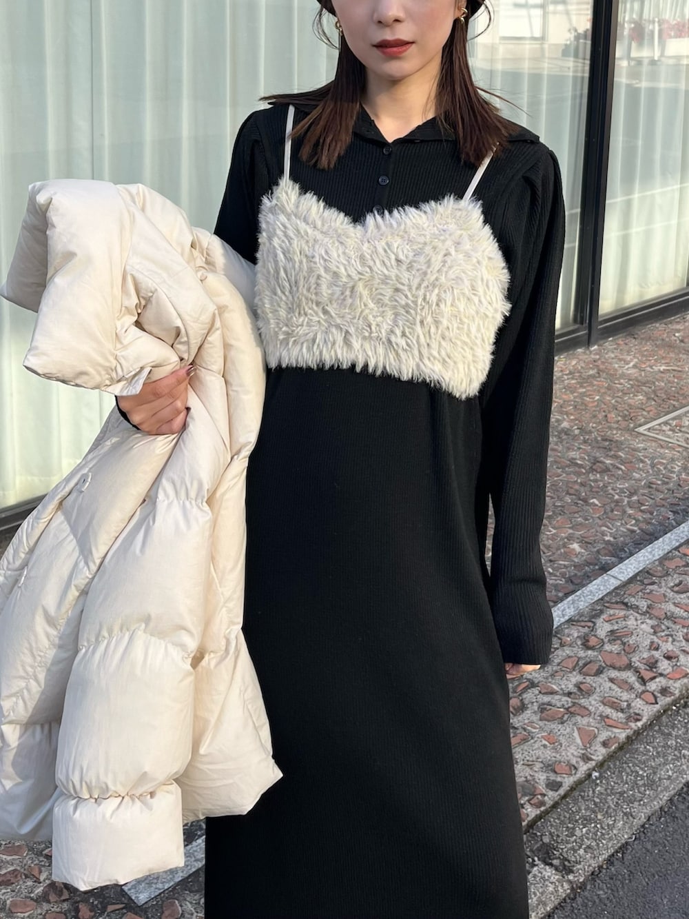 ブラック系のワンピース、ホワイト系のダウンジャケット/コート、グリーン系のトップスを着用したレディースの冬コーディネートの3枚目の写真