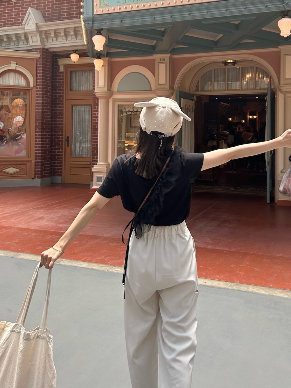 ホワイト系のその他パンツ、ブラック系のTシャツ/カットソー、ブラウン系のショルダーバッグを着用したレディースの夏コーディネートの4枚目の写真