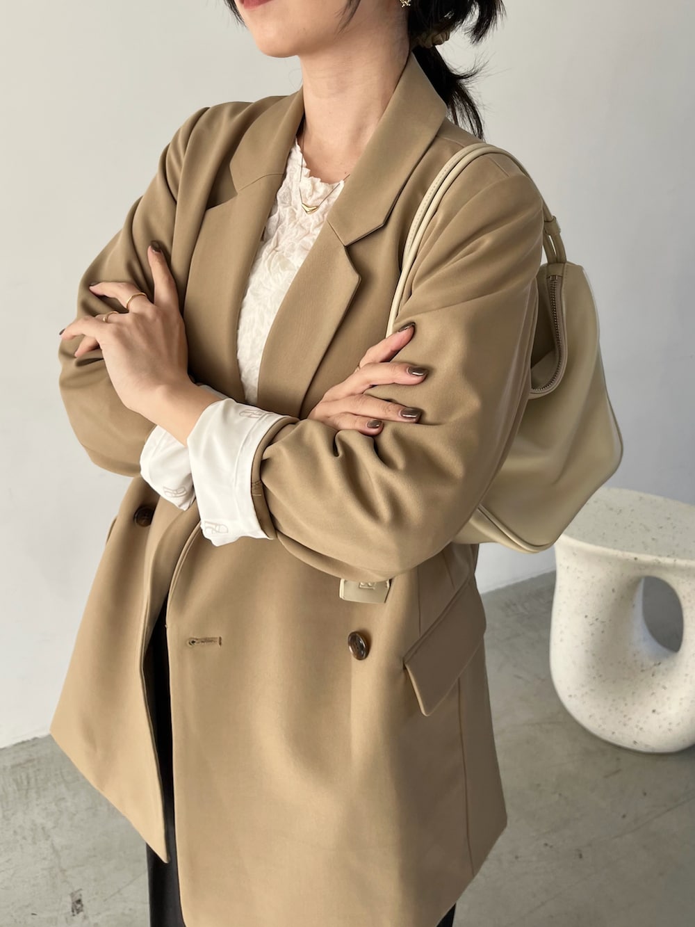 ホワイト系のニット/セーター、ベージュ系のテーラードジャケット、ブラック系のその他パンツを着用したレディースの冬コーディネートの4枚目の写真