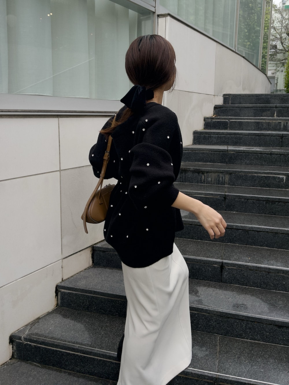 ホワイト系のスカート、ブラック系のカーディガン/ボレロ、イエロー系のショルダーバッグを着用したレディースの秋コーディネートの5枚目の写真