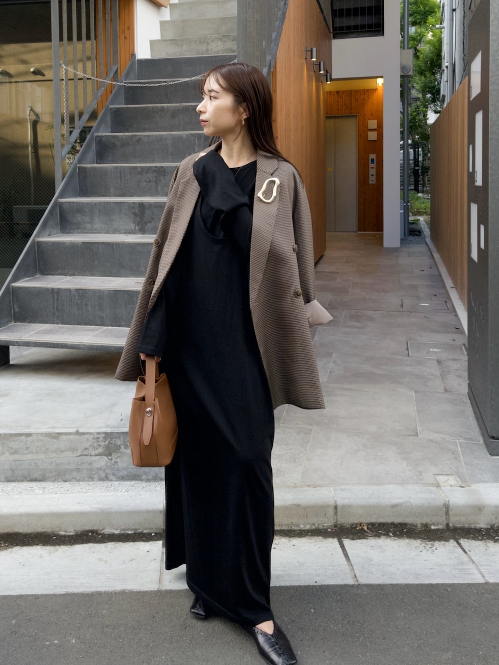 ブラック系のワンピース、ブラウン系のテーラードジャケット、ブラウン系のショルダーバッグを着用したレディースの秋コーディネートの2枚目の写真
