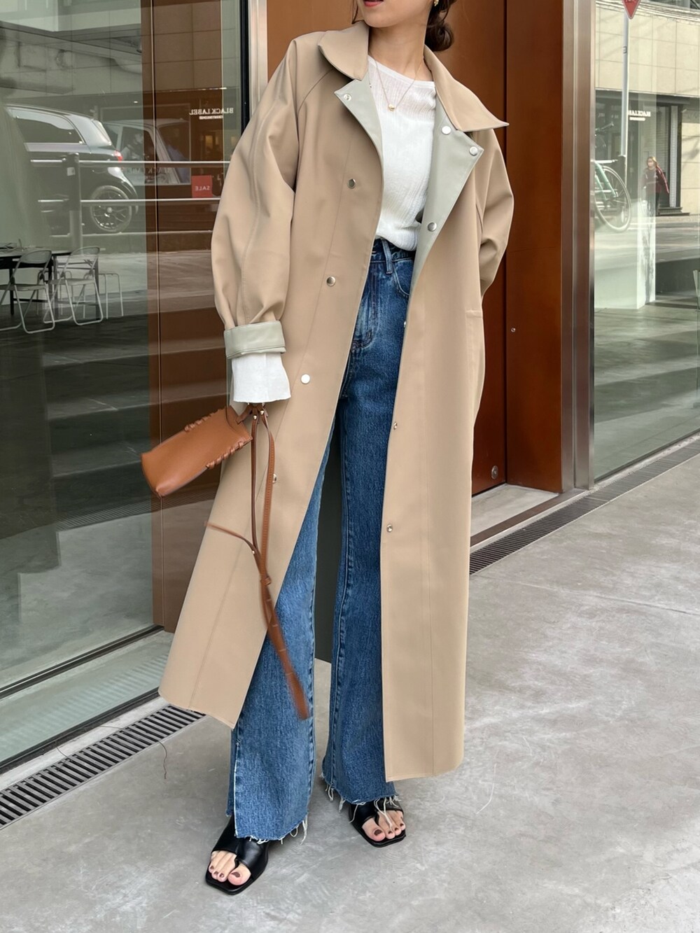 ブルー系のデニムパンツ、グリーン系のその他アウター、ホワイト系のニット/セーターを着用したレディースの冬コーディネートの4枚目の写真