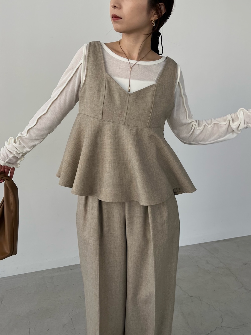 ベージュ系のその他パンツ、イエロー系のショルダーバッグ、ブラック系のパンプスを着用したレディースの冬コーディネートの4枚目の写真