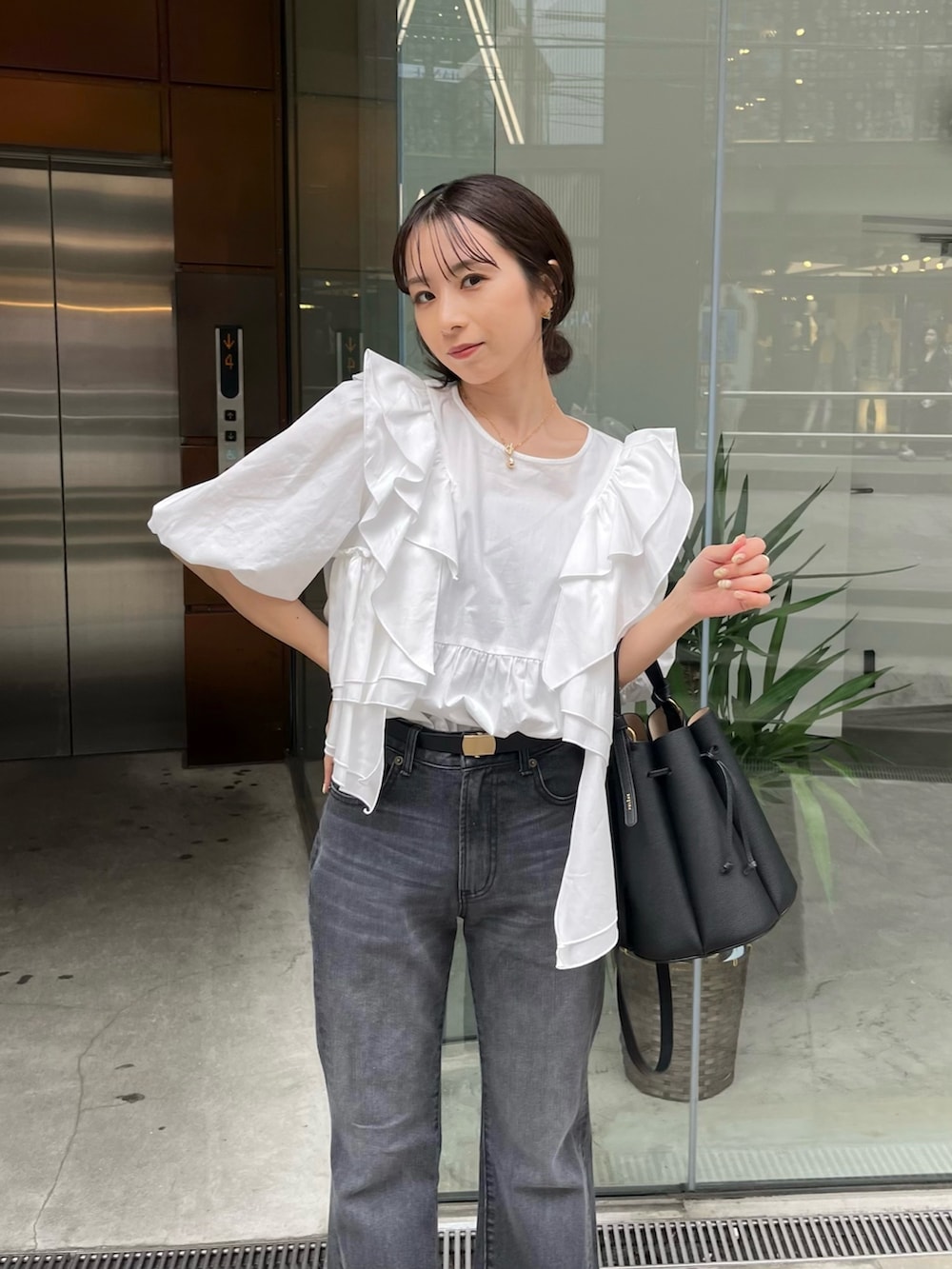 ホワイト系のシャツ/ブラウス、ブラック系のバッグ、ブラック系のサンダルを着用したレディースの春コーディネートの2枚目の写真