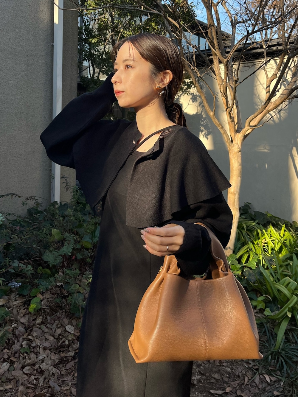 ブラック系のワンピース、ブラウン系のバッグ、ホワイト系のその他を着用したレディースの冬コーディネートの5枚目の写真