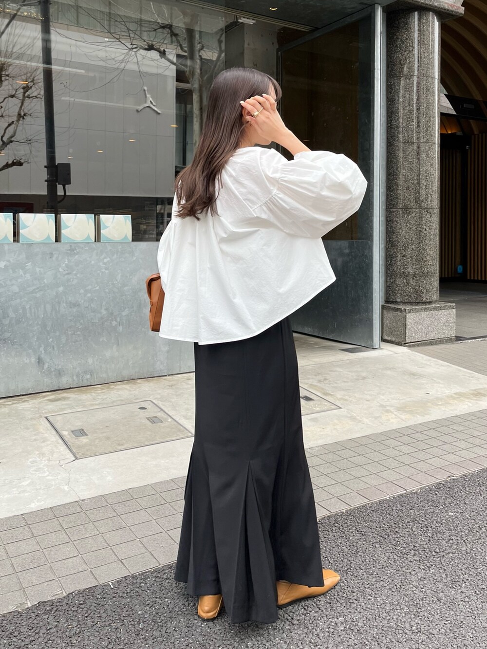 ブラック系のスカート、ホワイト系のシャツ/ブラウス、ブラウン系のトートバッグを着用したレディースの春コーディネートの3枚目の写真