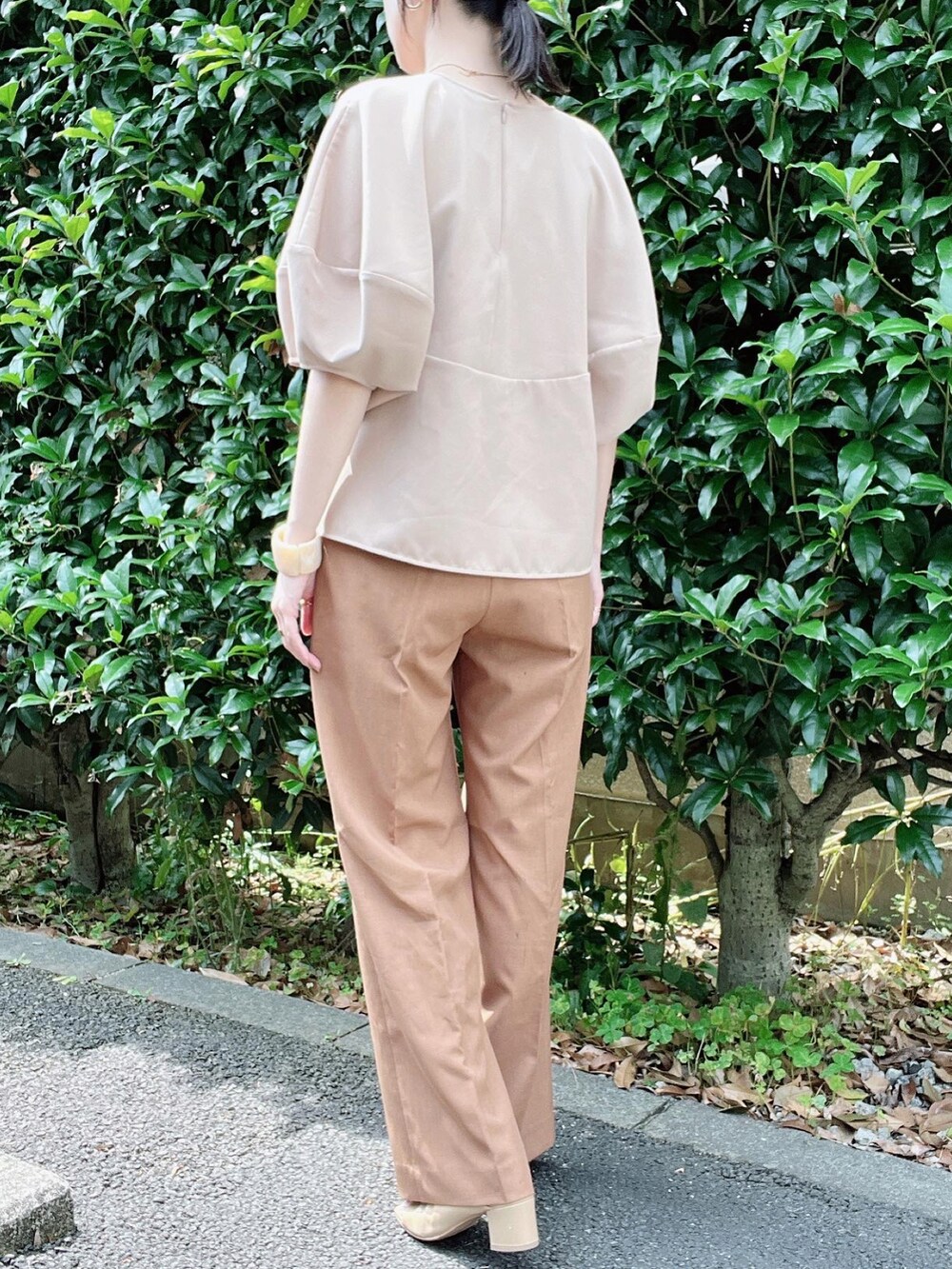 ベージュ系のシャツ/ブラウス、オレンジ系のスラックス、ベージュ系のパンプスを着用したレディースの夏コーディネートの3枚目の写真