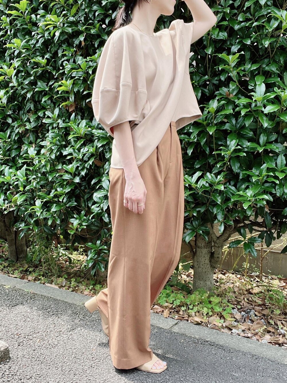 ベージュ系のシャツ/ブラウス、オレンジ系のスラックス、ベージュ系のパンプスを着用したレディースの夏コーディネートの2枚目の写真