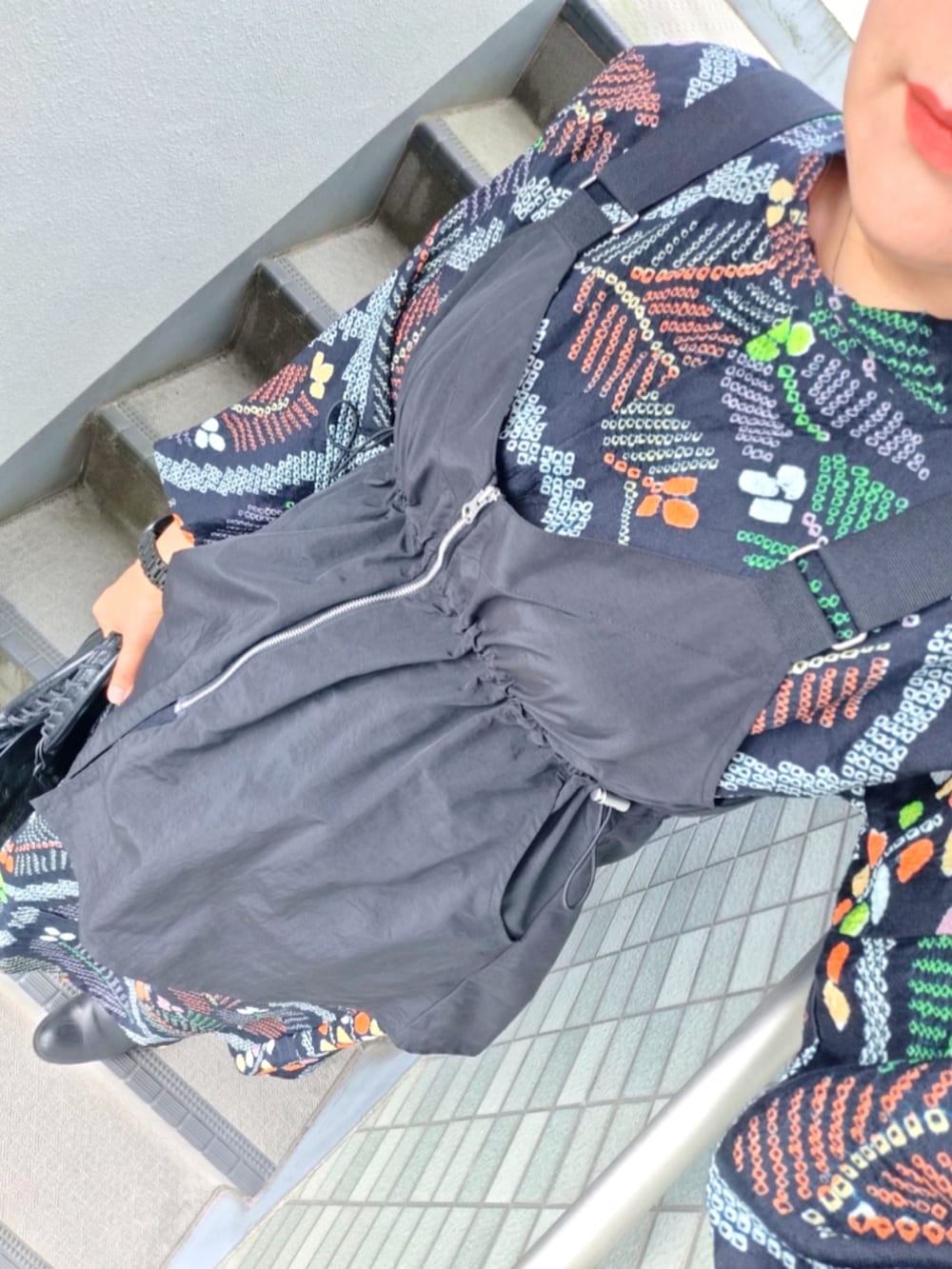 ブラック系のブーツ、ブラック系のデニムパンツ、ブラック系のショルダーバッグを着用したレディースの春コーディネートの3枚目の写真