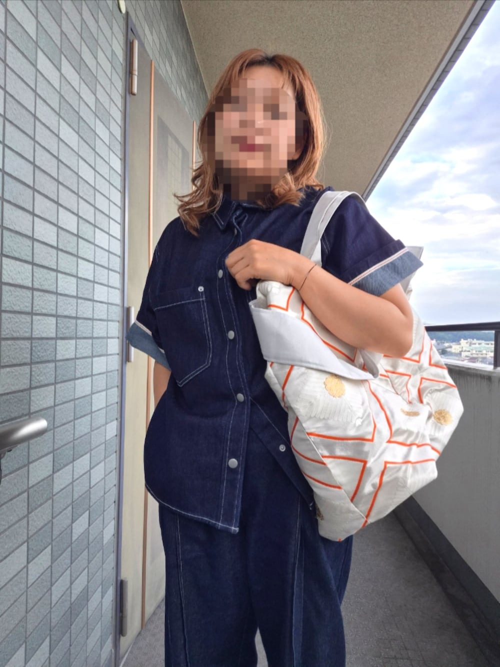 ブルー系のデニムパンツ、ブラック系のサンダル、ブルー系のデニムジャケットを着用したレディースの秋コーディネートの3枚目の写真
