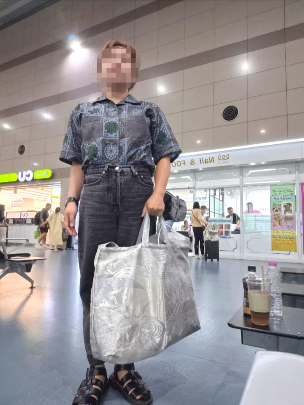 ブラック系のサンダル、グレー系のデニムパンツ、シルバー系のメッセンジャーバッグを着用したレディースの夏コーディネートの3枚目の写真