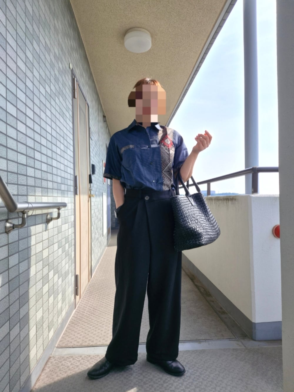 ブラック系のスラックス、ブルー系のシャツ/ブラウス、ブラック系のトートバッグを着用したレディースの夏コーディネートの2枚目の写真