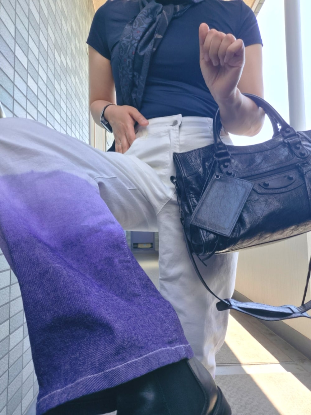 ホワイト系のデニムパンツ、ブラック系のショルダーバッグ、ブルー系のストール/ショールを着用したレディースの春コーディネートの2枚目の写真