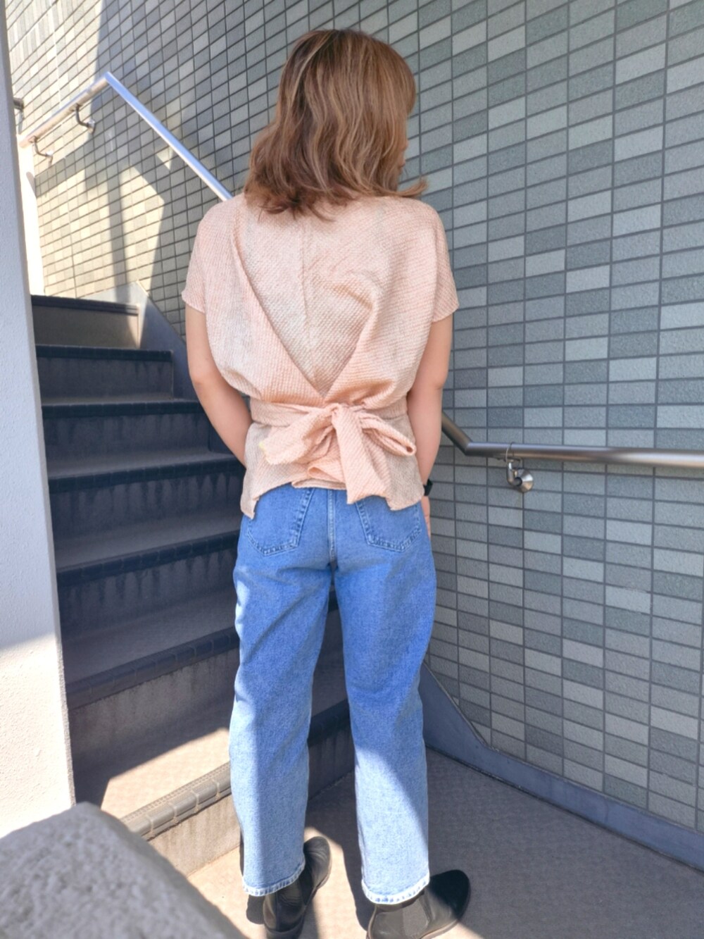 ブルー系のデニムパンツ、ピンク系のシャツ/ブラウスを着用したレディースの春コーディネートの3枚目の写真