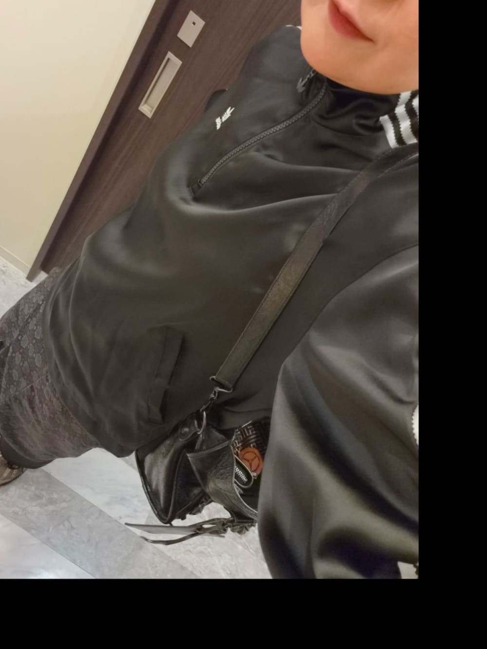ブラック系のスカート、ブラック系のジャージ、ブラック系のショルダーバッグを着用したレディースの秋コーディネートの3枚目の写真