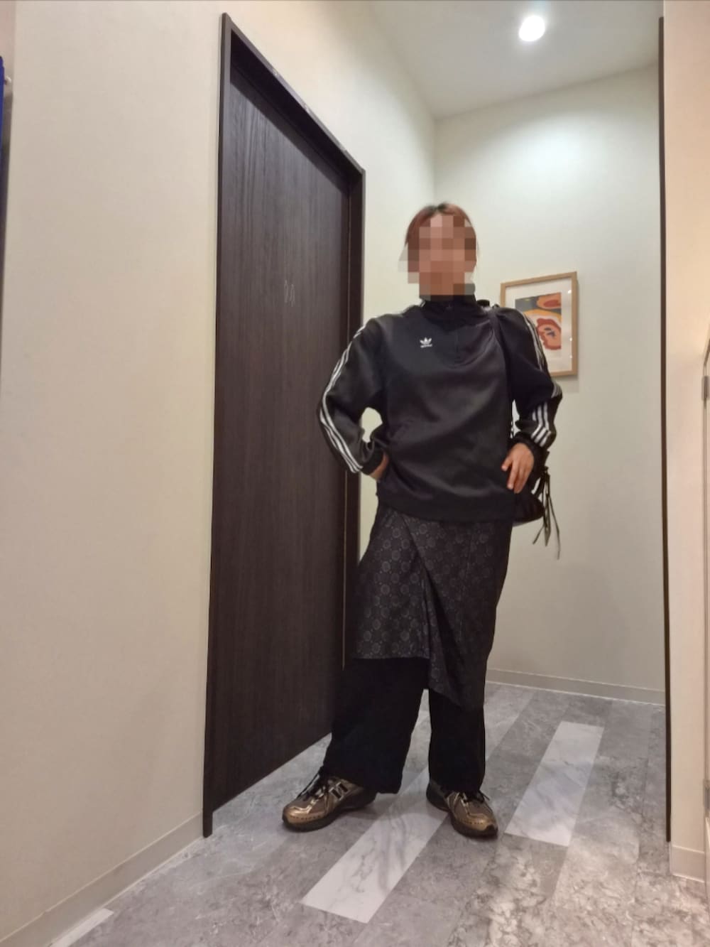 ブラック系のスカート、ブラック系のジャージ、ブラック系のショルダーバッグを着用したレディースの秋コーディネートの2枚目の写真