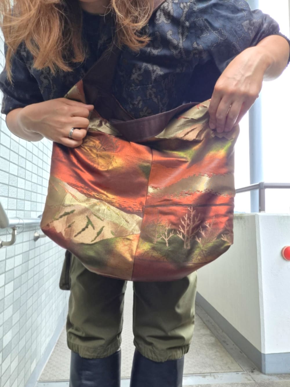 グリーン系のカーゴパンツ、ブルー系のシャツ/ブラウス、ブラウン系のショルダーバッグを着用したレディースの秋コーディネートの4枚目の写真