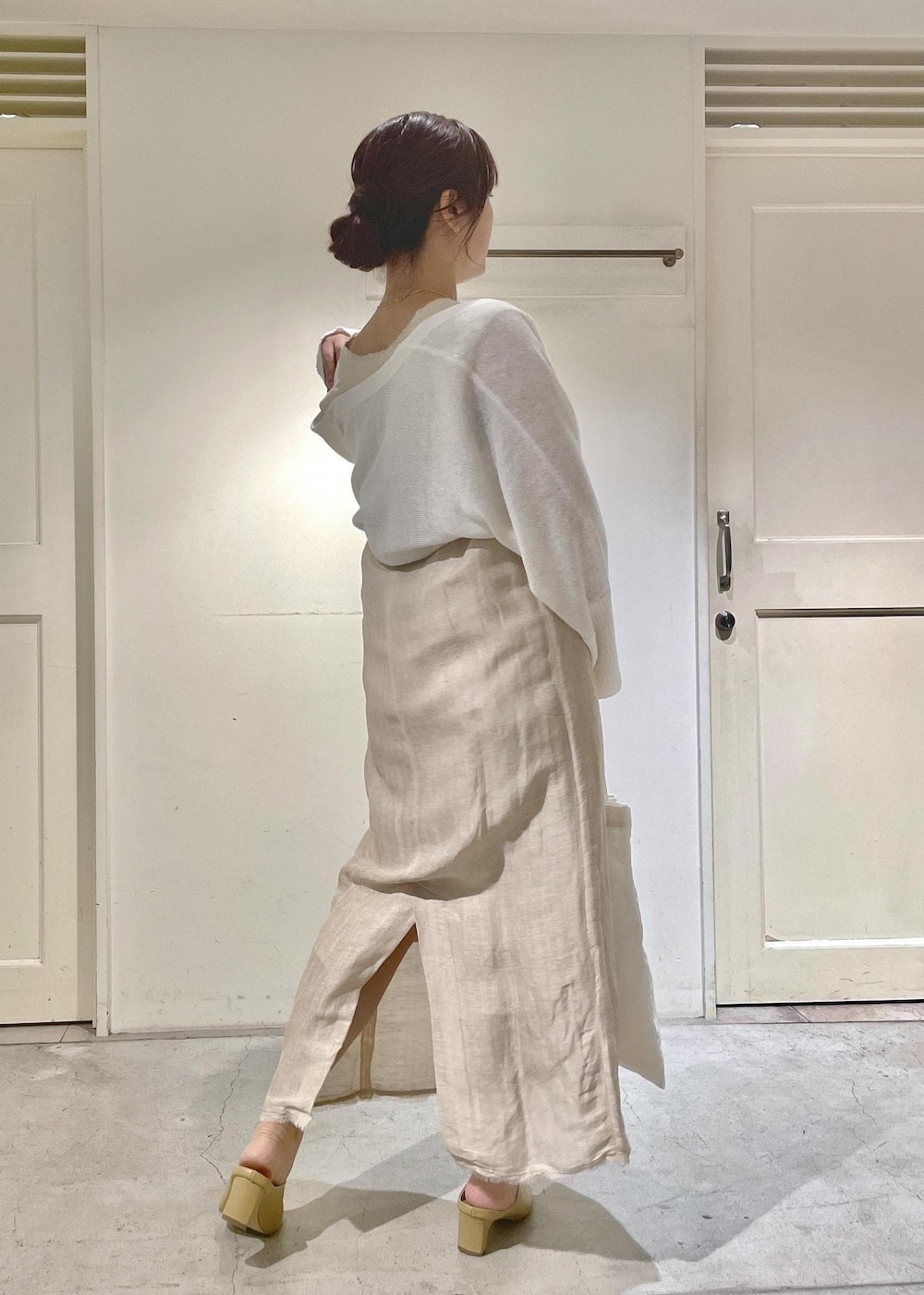 ホワイト系のサンダル、ホワイト系のカーディガン/ボレロ、ホワイト系のジャンパースカートを着用したレディースの夏コーディネートの2枚目の写真