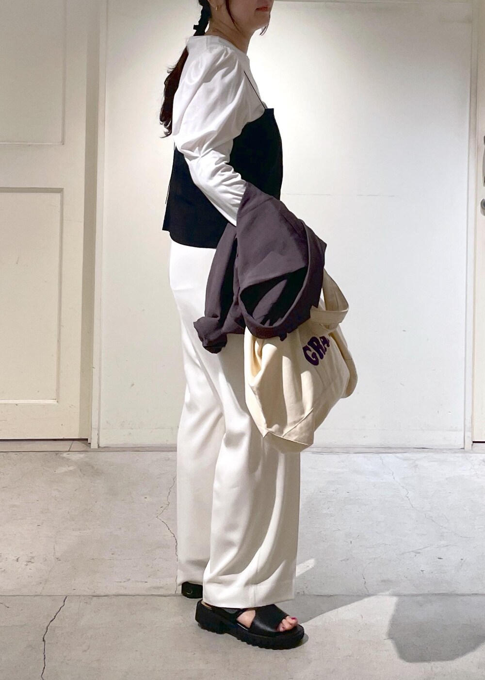 ブラック系のキャミソール、ホワイト系のスラックス、グレー系のテーラードジャケットを着用したレディースの春コーディネートの5枚目の写真