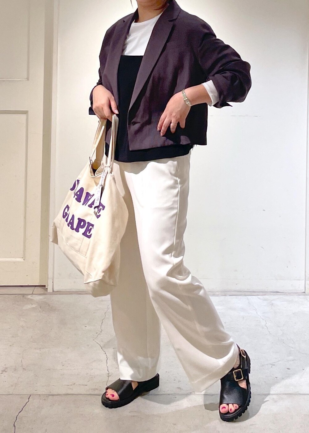 ブラック系のキャミソール、ホワイト系のスラックス、グレー系のテーラードジャケットを着用したレディースの春コーディネートの2枚目の写真