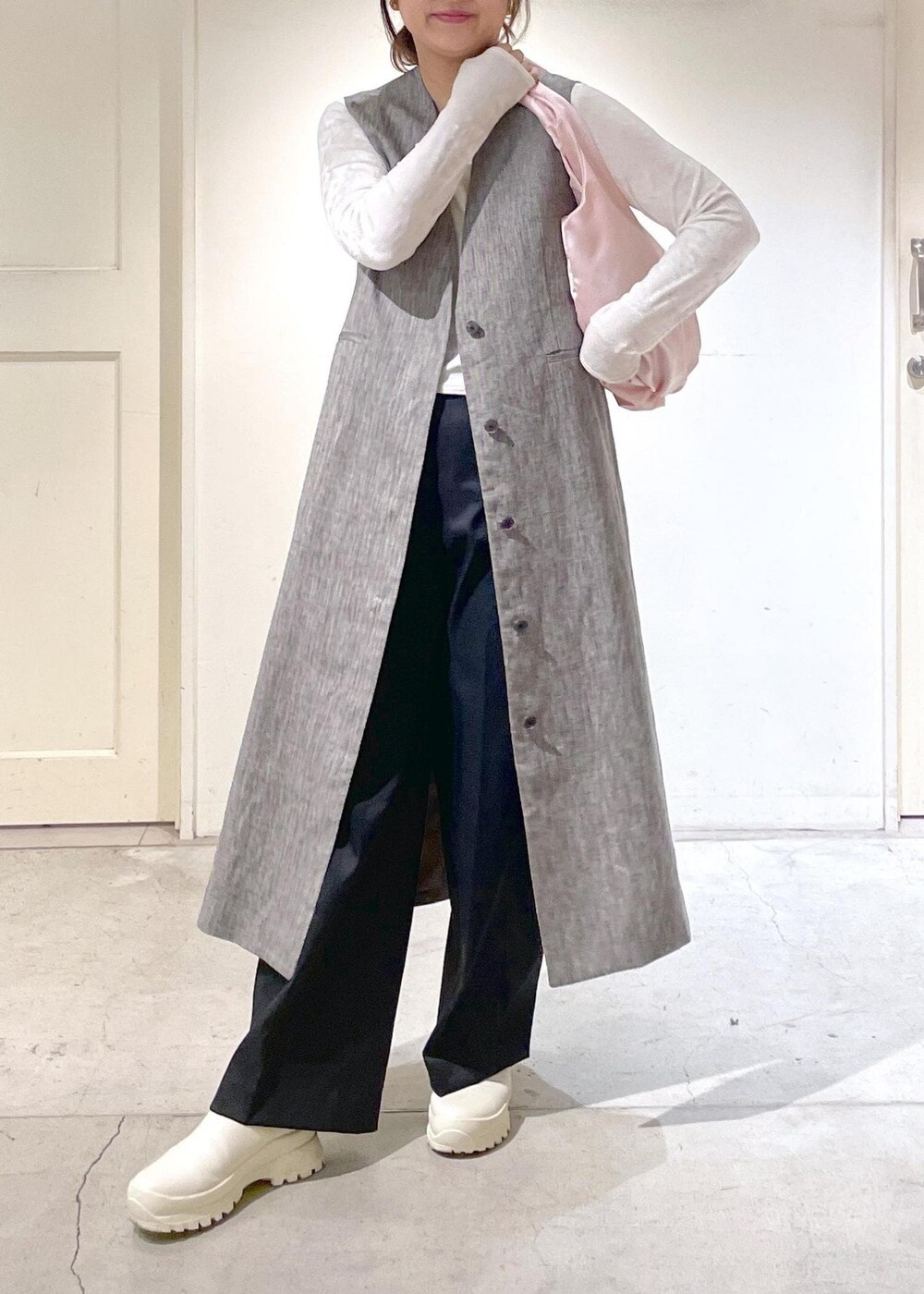 ブラック系のジャンパースカート、ブラック系のその他パンツ、ホワイト系のTシャツ/カットソーを着用したレディースの冬コーディネートの2枚目の写真