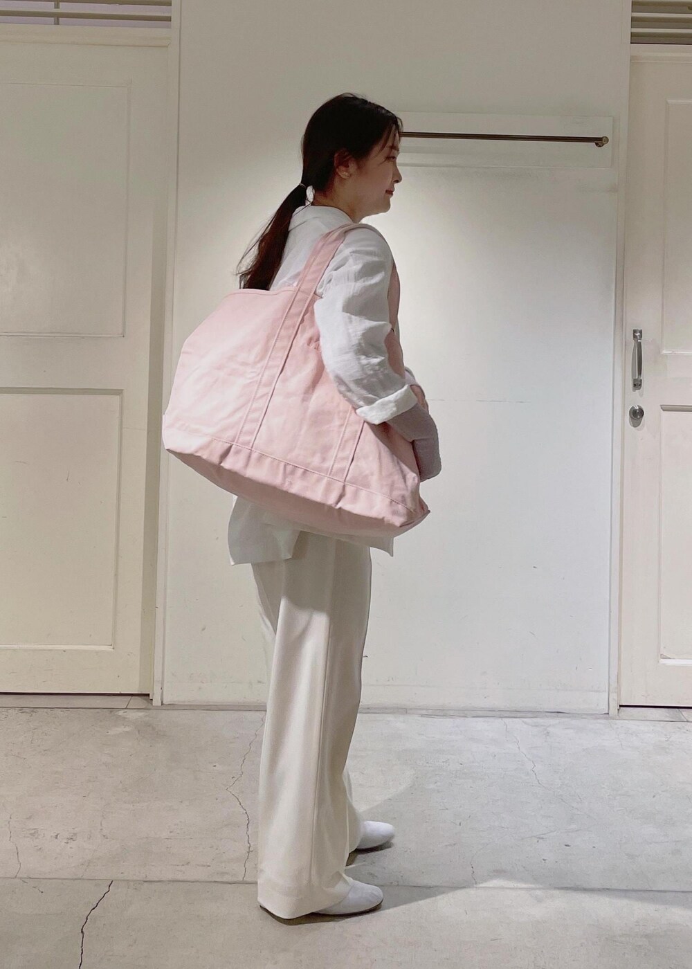 ホワイト系のその他シューズ、ピンク系のTシャツ/カットソー、ホワイト系のスラックスを着用したレディースの春コーディネートの2枚目の写真