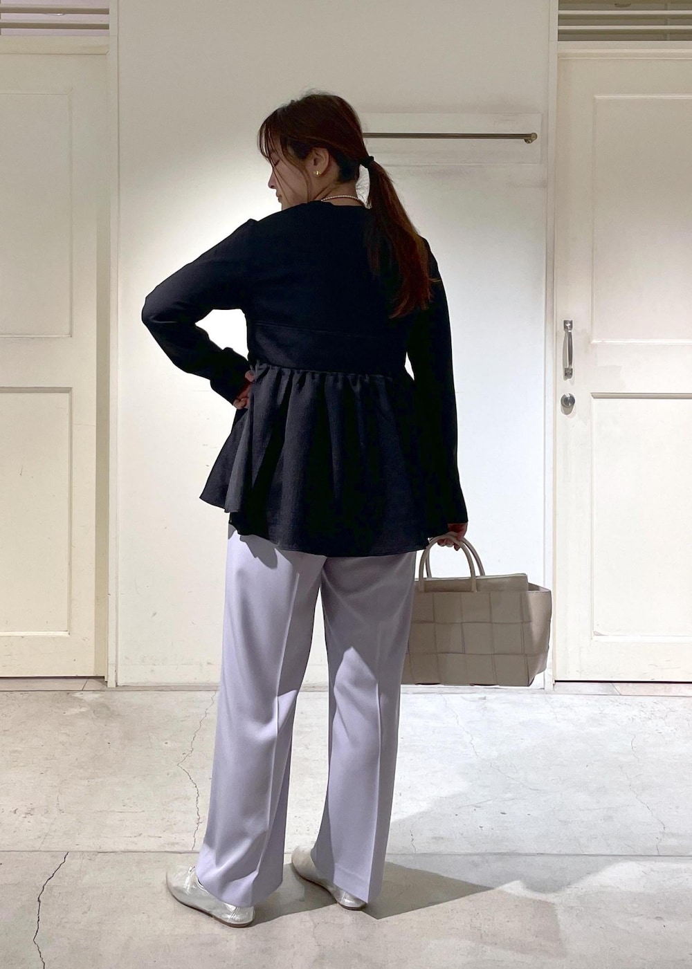 シルバー系のその他シューズ、ホワイト系のトートバッグ、ブラック系のTシャツ/カットソーを着用したレディースの春コーディネートの3枚目の写真